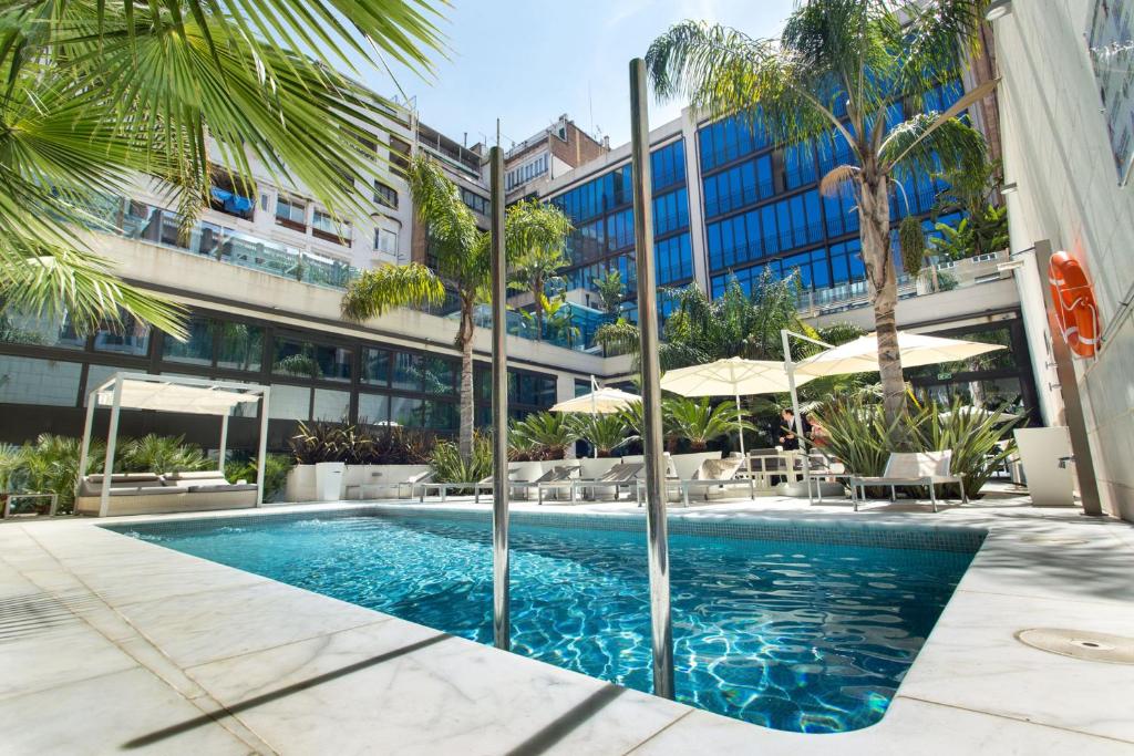 a swimming pool in front of a building at Hotel Indigo Barcelona - Plaza Catalunya 4Sup, an IHG Hotel in Barcelona