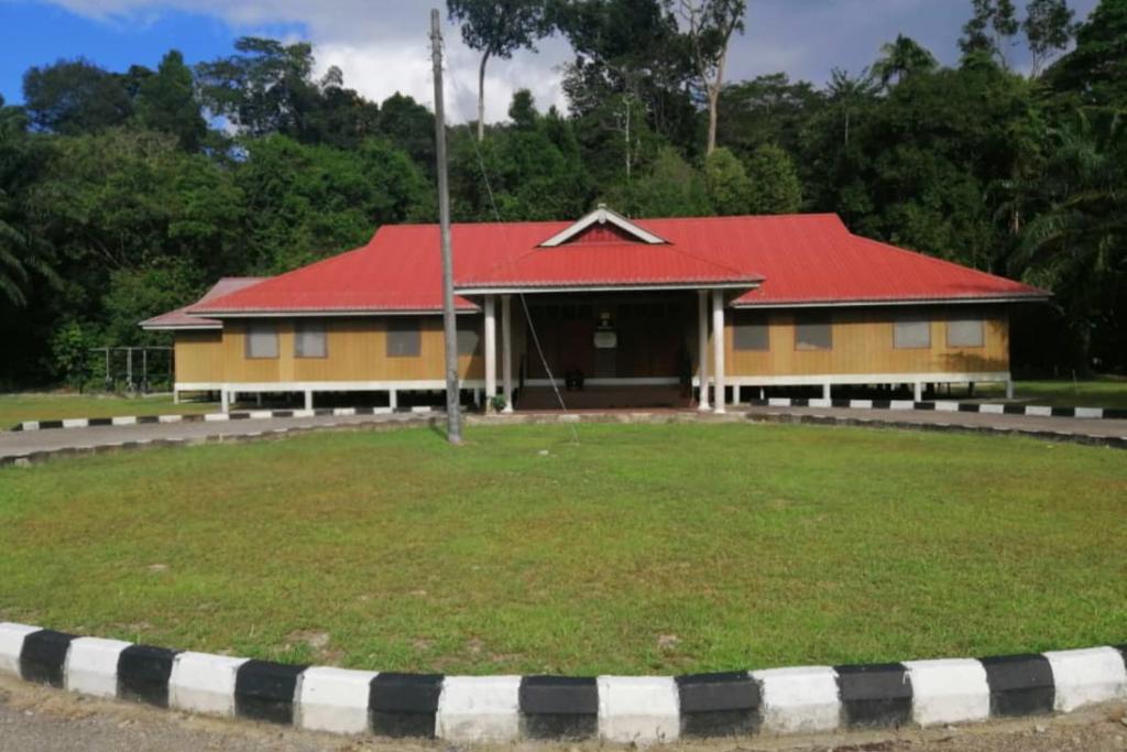 una casa gialla e rossa con tetto rosso di SPOT ON 90014 Otternest @ Gunung Pulai 2 a Pontian Besar
