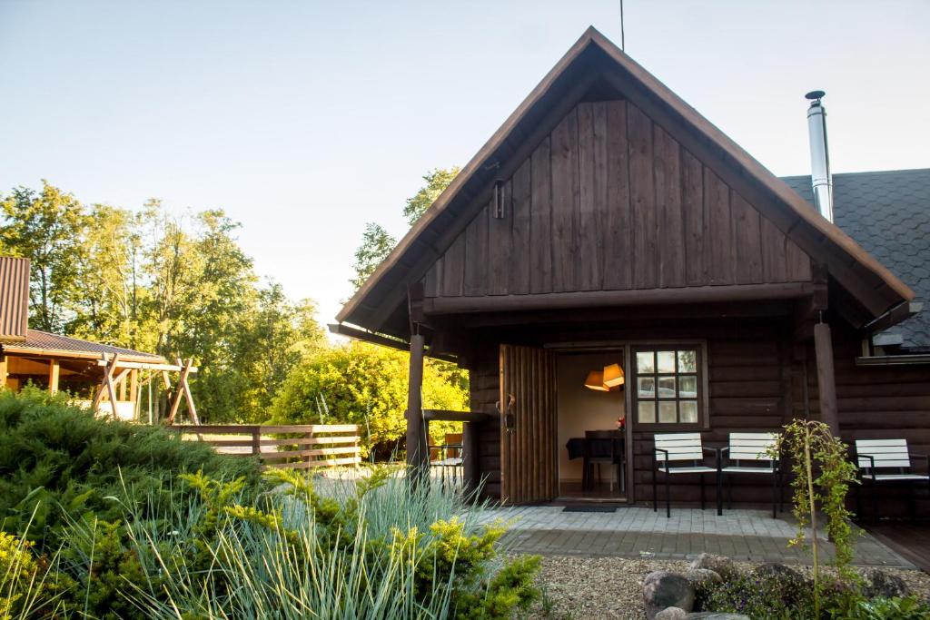 a log cabin with a porch and a patio at Naktsmājas APĒ in Ape