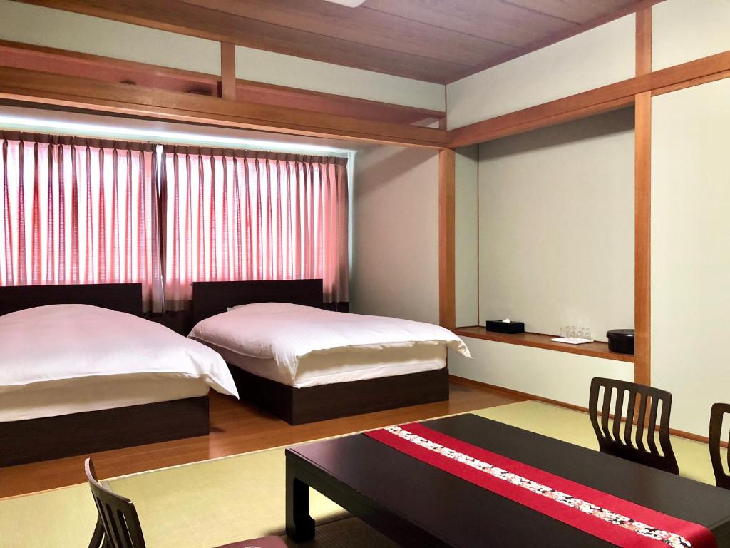 Postel nebo postele na pokoji v ubytování Hotel Takasago
