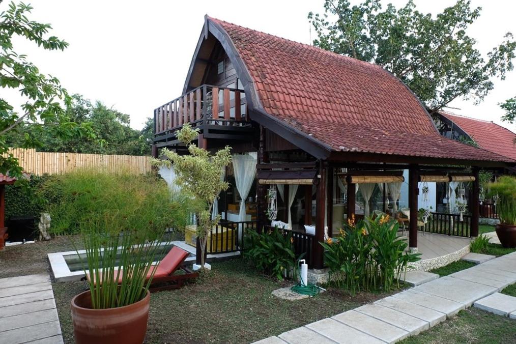 a house with a red roof and some plants at Le Kekeri Villas Collection in Mataram