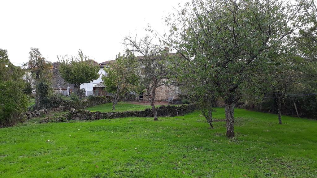 een grasveld met bomen en gebouwen bij Gite No 16 in Châteauponsac