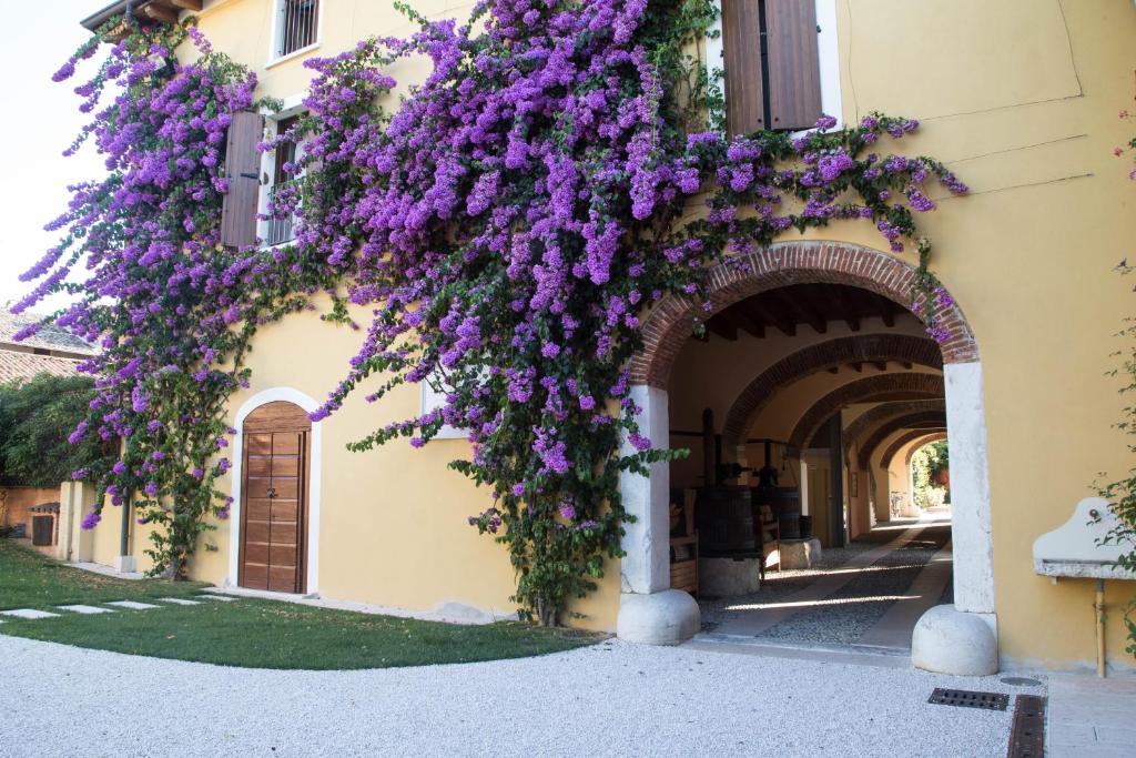 an archway with purple flowers on a building at Agriturismo La Filanda in Manerba del Garda