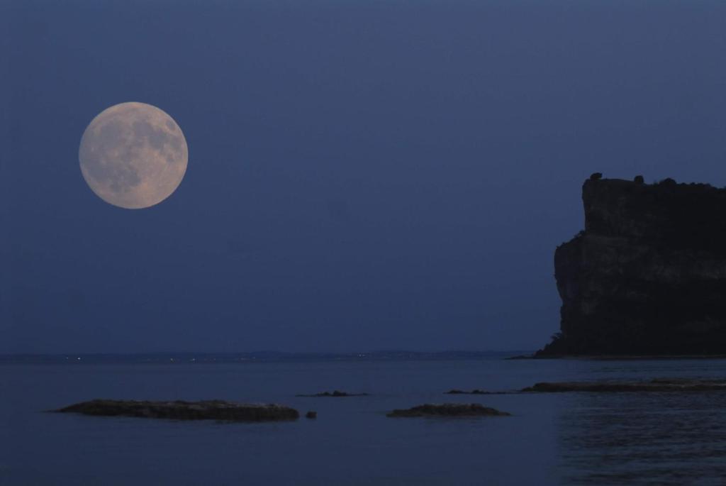 a full moon rising over the ocean at night at Agriturismo La Filanda in Manerba del Garda
