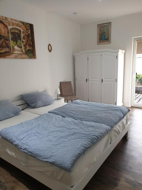 a bedroom with a large bed with a blue blanket at Villa Ferialis in Xanten