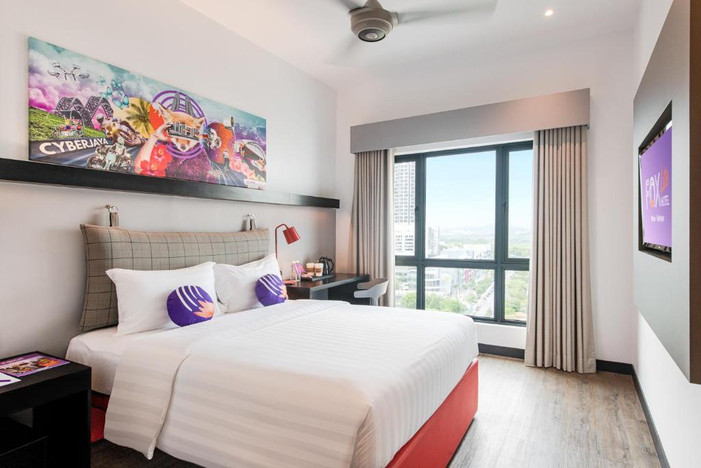 ein Schlafzimmer mit einem großen Bett und einem großen Fenster in der Unterkunft FOX Lite DPulze Cyberjaya by Ascott in Cyberjaya