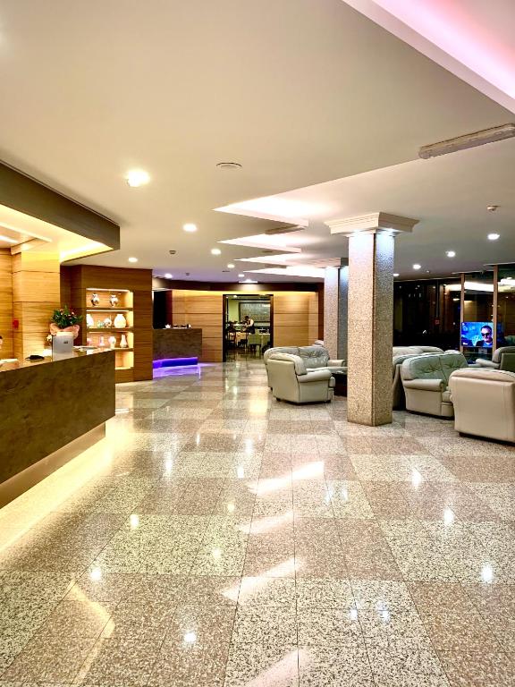 hol z kanapami i krzesłami w budynku w obiekcie Hotel Grillo w mieście Assemini