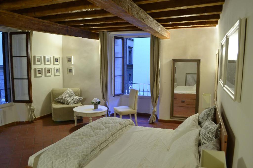 a bedroom with a bed and a chair and a table at Dante's Relais in Florence