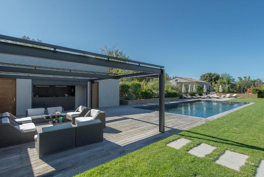 a backyard with a swimming pool and a patio with furniture at Domaine Rampale in Fuveau