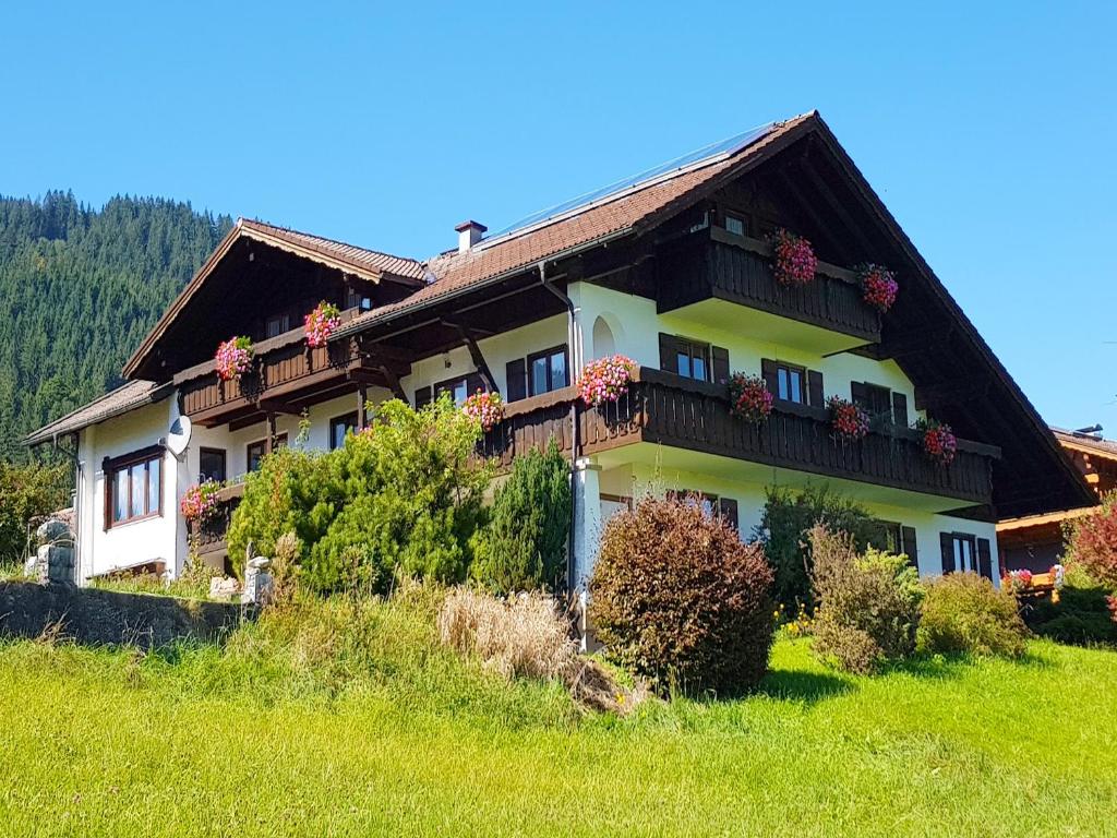 Una casa en una colina con flores. en Ferienwohnung im Haus Dorn-Röschen, en Pfronten