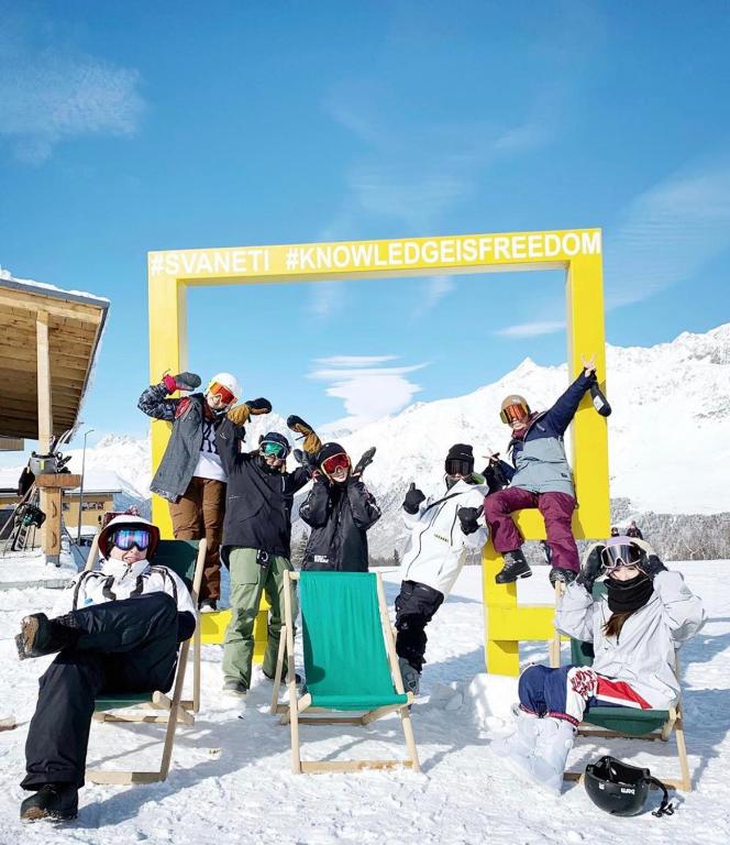 a group of people sitting in chairs in the snow at Hotel panorama svaneti in Mestia