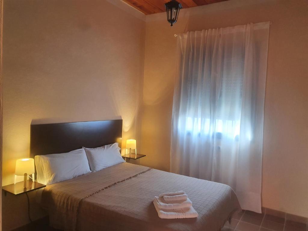 a bedroom with a bed with two towels on it at Alojamiento Rural Flamingo in El Rocío