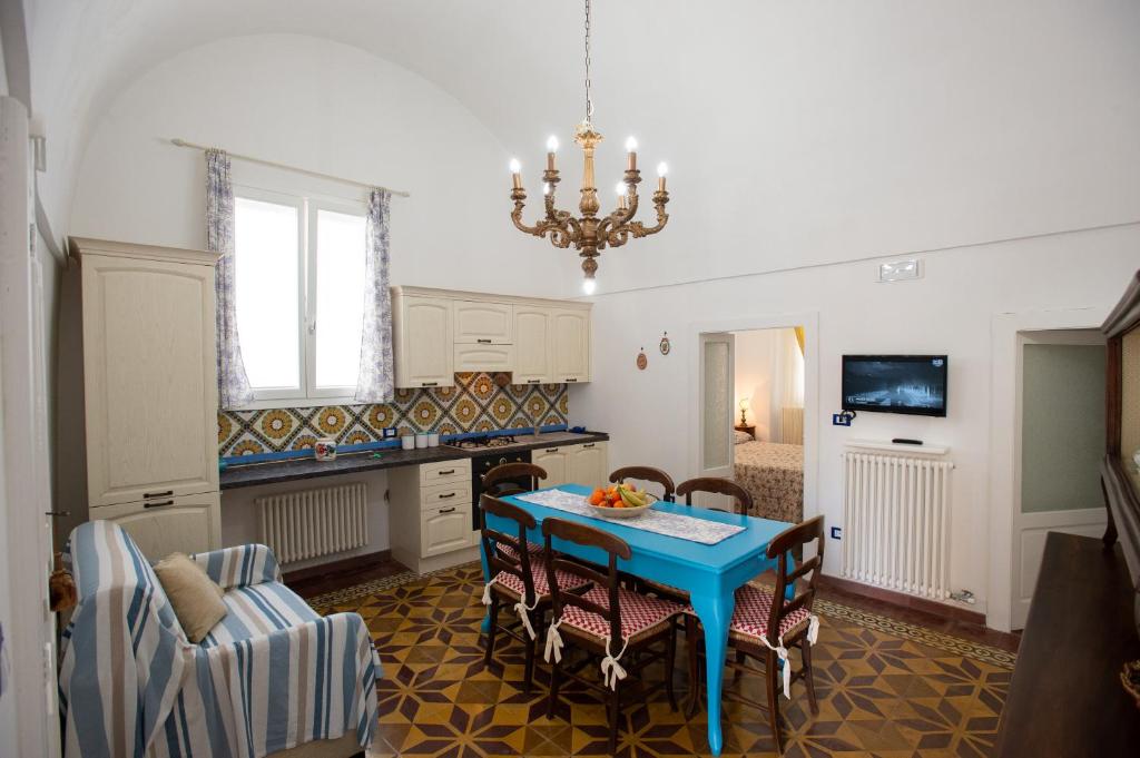 a kitchen with a table and chairs and a chandelier at La Casa nel Vico in Marittima