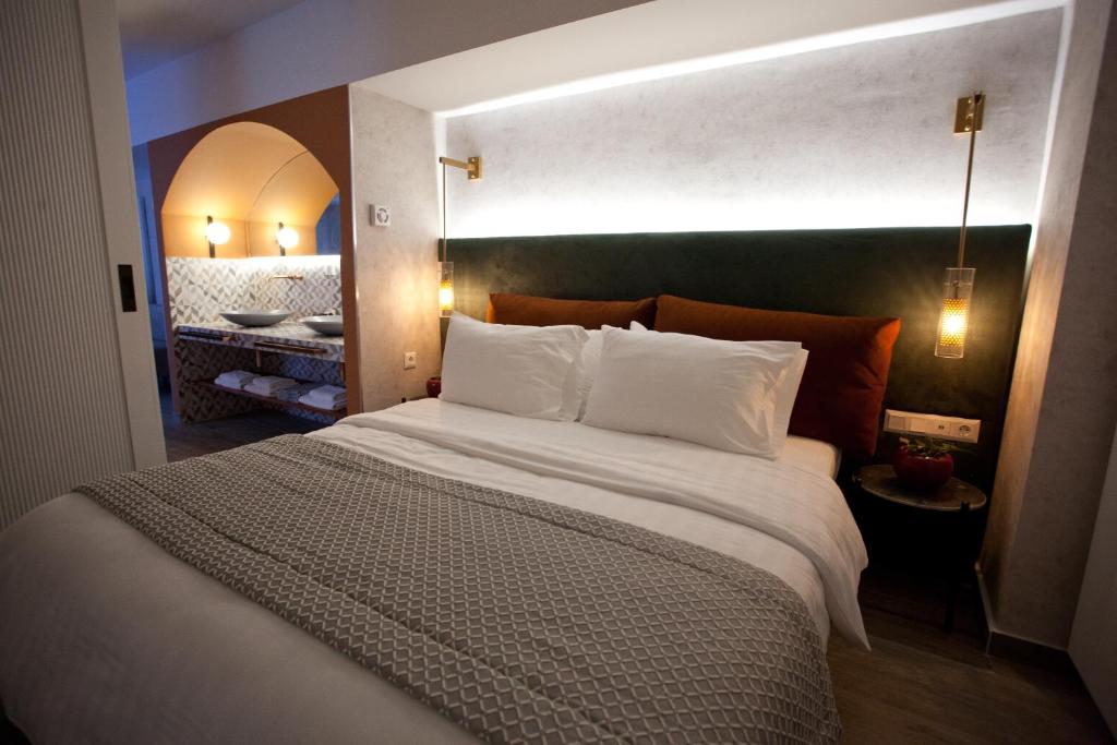 a bedroom with a large bed with white pillows at Noufara in Piraeus