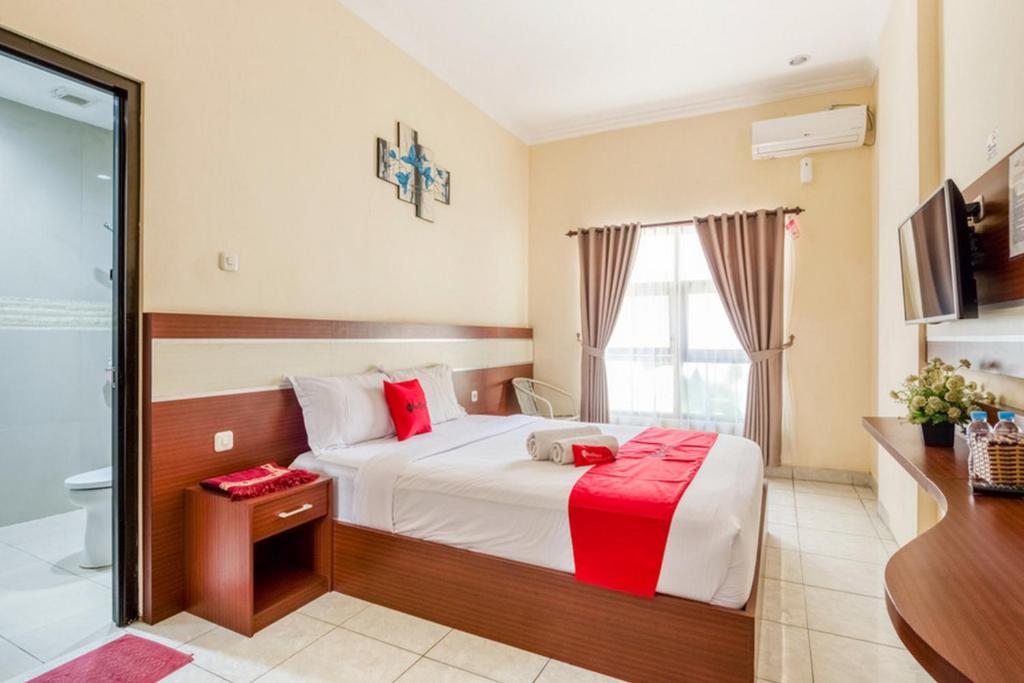 a hotel room with a bed and a bathroom at RedDoorz Syariah @ Jalan Simpang Gajayana in Malang