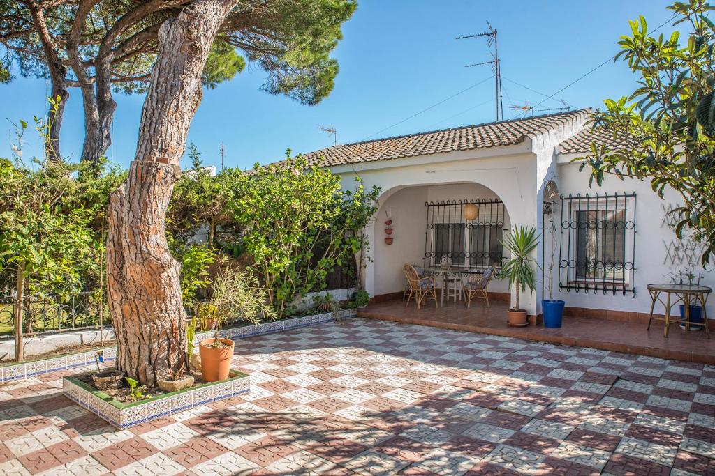a house with a tree and a patio at Casa Venice in Chiclana de la Frontera