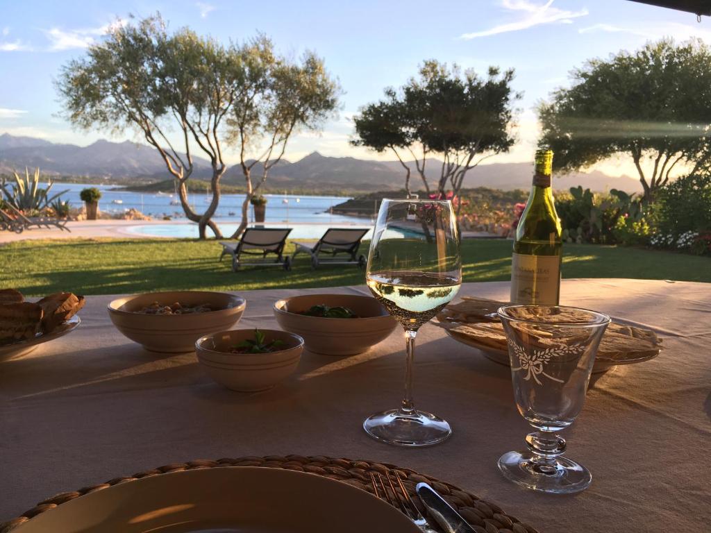 a table with a bottle of wine and a glass at Villa Carlotta in San Teodoro