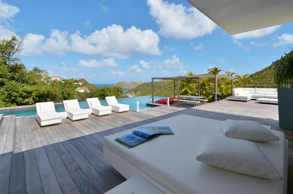 un patio con tumbonas blancas y una piscina en Dream Villa Flamands 744, en Anse des Cayes