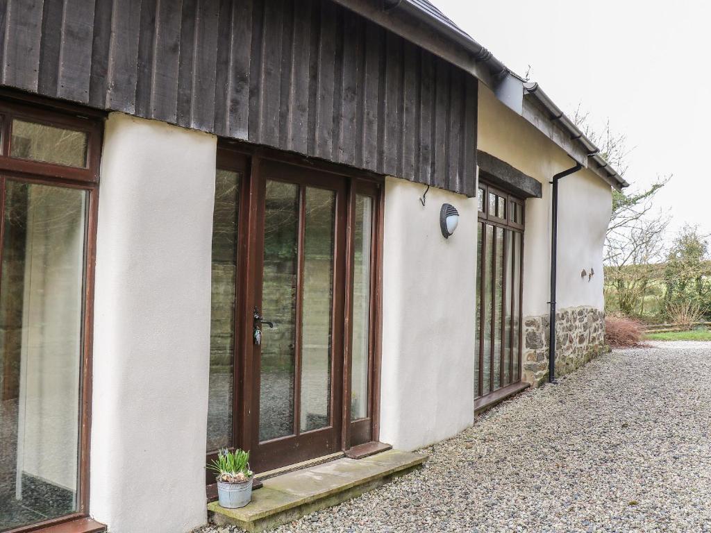 a house with glass doors on the side of it at Old Stable Cottage in Okehampton