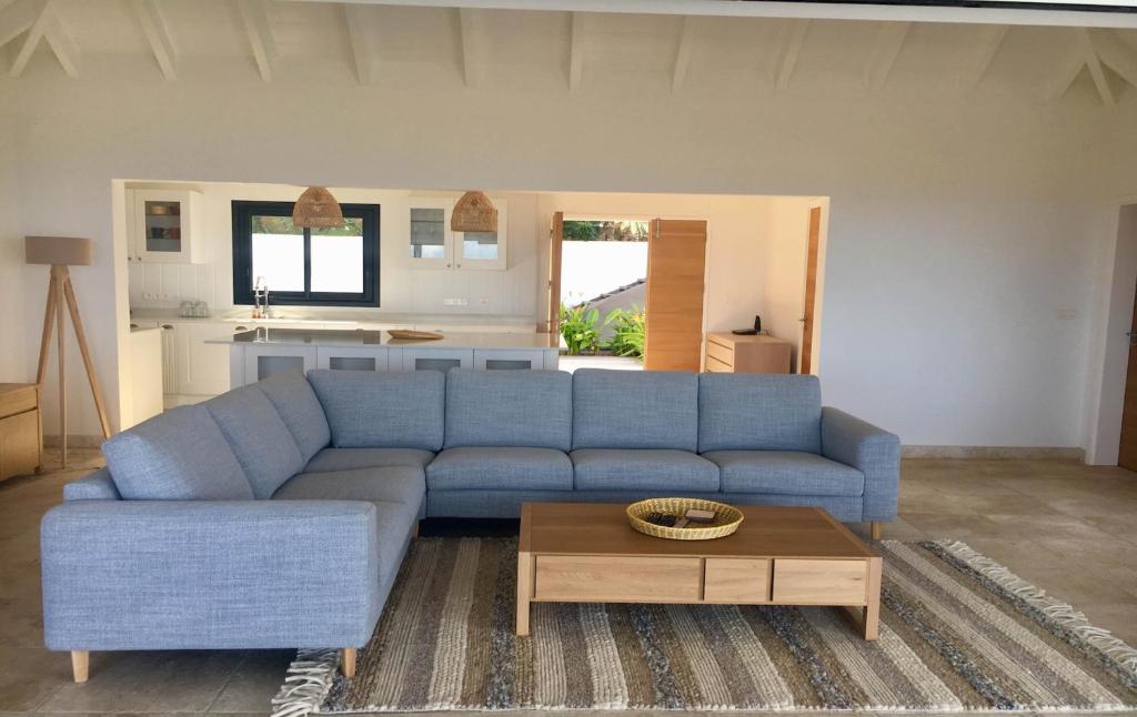 a living room with a blue couch and a coffee table at Dream Villa Vitet 1346 in Gustavia