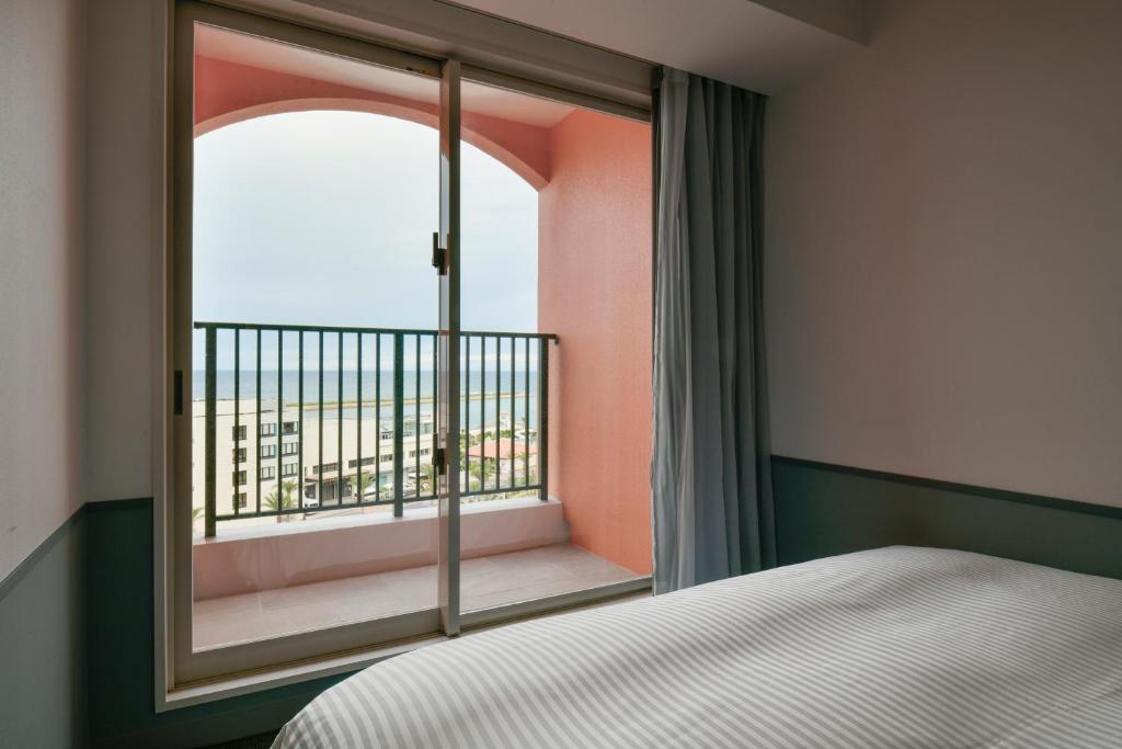 Postel nebo postele na pokoji v ubytování Lequ Okinawa Chatan Spa ＆ Resort