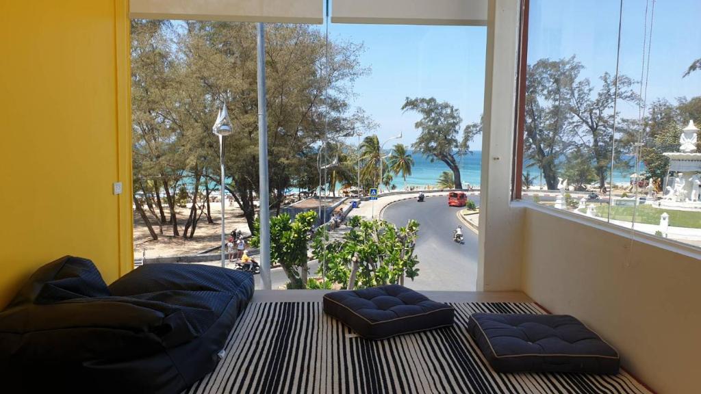 Cette chambre dispose d'une grande fenêtre offrant une vue sur la rue. dans l'établissement Fishtail Hostel Phuket, à Karon Beach