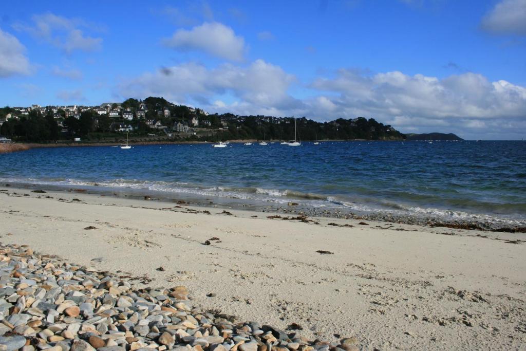 einen Strand mit Felsen und Booten im Wasser in der Unterkunft Bel appartement rénové VUE PANORAMIQUE SUR MER à PERROS-GUIREC - ref 822 in Perros-Guirec