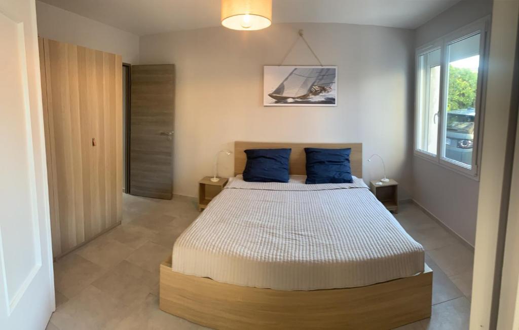 a bedroom with a large bed with blue pillows at Boost Your Immo Six Fours Les Plages le Mistral 252 in Six-Fours-les-Plages