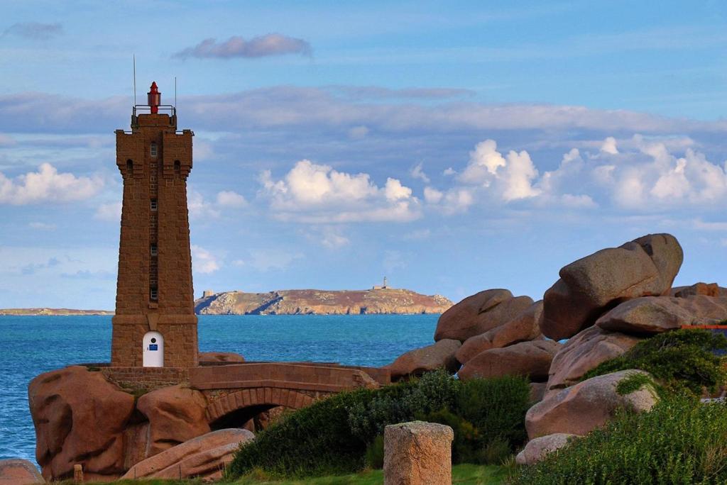 un phare sur les rochers à côté de l'eau dans l'établissement Appartement au dernier étage plage de Trestraou à PERROS-GUIREC - ref 858, à Perros-Guirec
