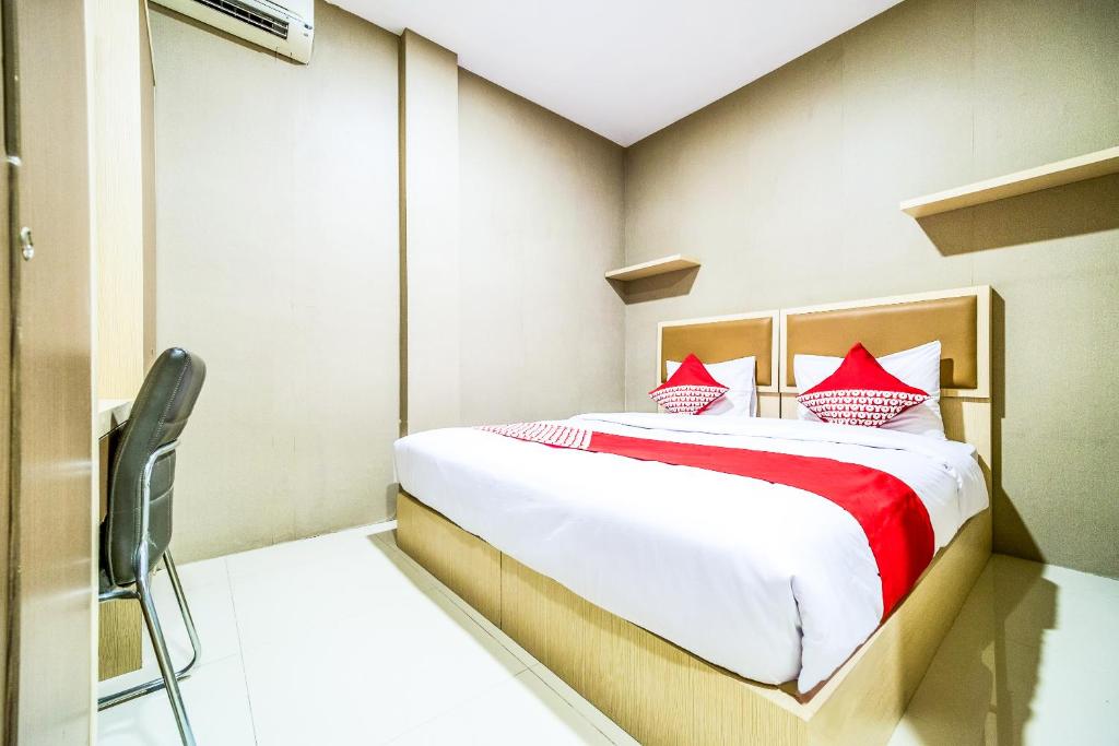 a bedroom with a bed with red pillows at OYO 279 Deli Homestay in Medan