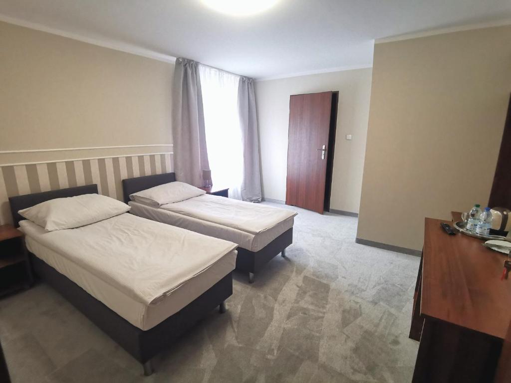 a hotel room with two beds and a window at Pokoje gościnne Rubin in Zielona Góra