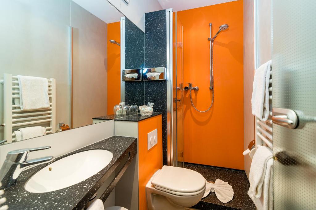 a bathroom with a toilet and a sink and a shower at Hotel & Gasthof Richard Held in Regensburg