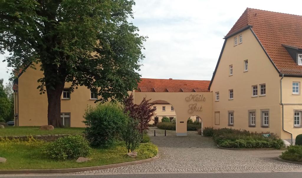 ein großes Gebäude mit einem Baum davor in der Unterkunft Landhotel Keils Gut in Wilsdruff