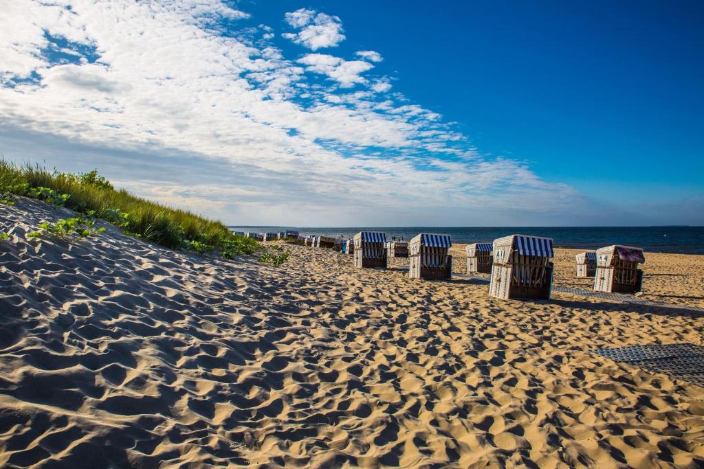 a row of trash cans on a sandy beach at Pension Fischerhaus in Trassenheide