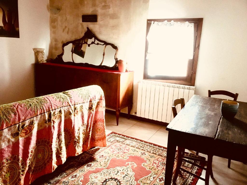 een woonkamer met een tafel en een spiegel bij Il residence della salute in Montese