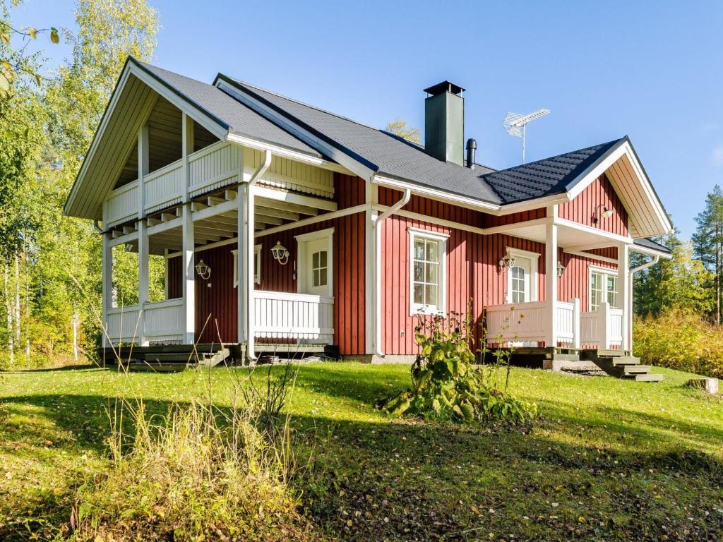 una casa roja con techo negro en un patio en Holiday Home Käränkämökki by Interhome en Kolinkylä