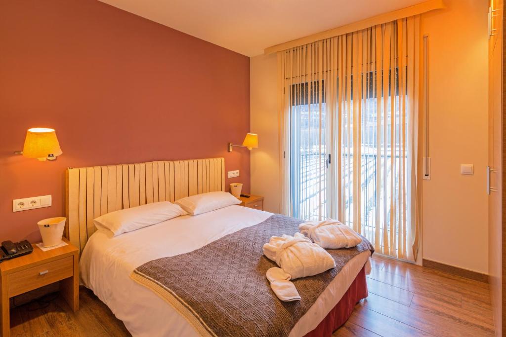 エステリ・ダネウにあるAparthotel Traineraのベッドルーム1室(ベッド1台、タオル2枚付)