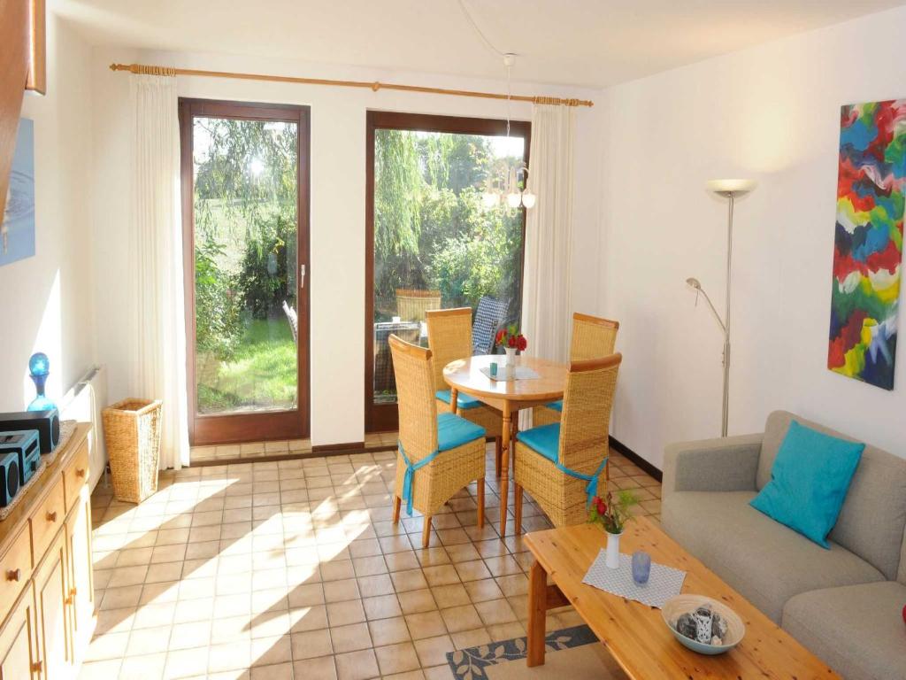 ein Wohnzimmer mit einem Tisch und einem Sofa in der Unterkunft La Casa Ferienwohnung Strandläufer in Steinberg