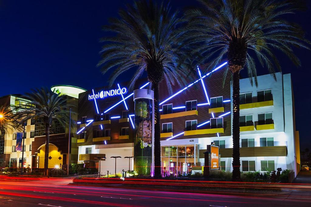 a hotel with palm trees in front of a building at Hotel Indigo Anaheim by IHG in Anaheim
