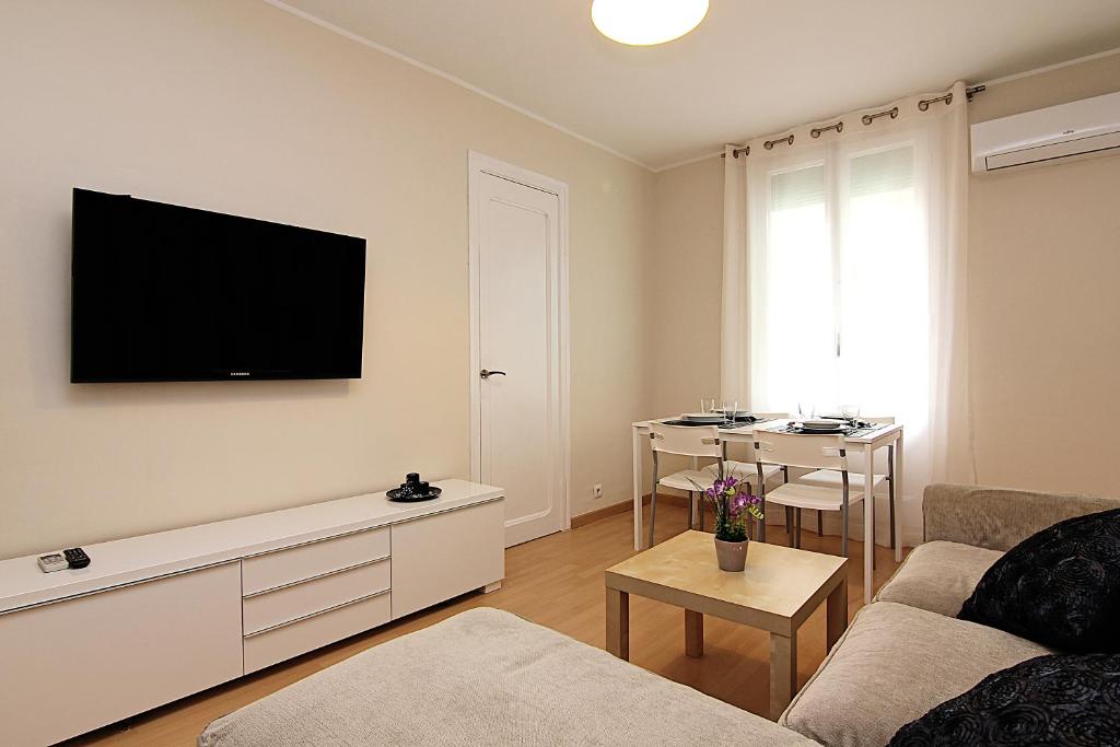 un soggiorno con un divano e una TV a parete di MUNNE - Spacious apartments next to FC Barcelona a Barcellona