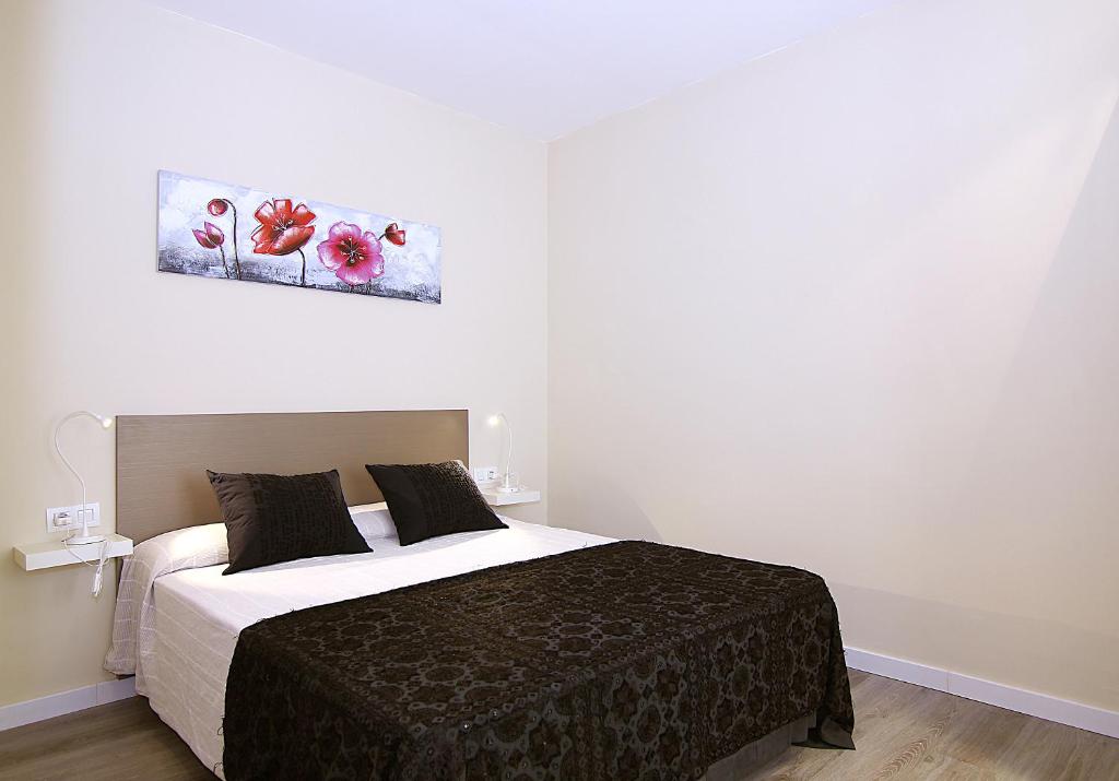 ein Schlafzimmer mit einem Bett und einem Wandgemälde in der Unterkunft MUNNE - Spacious apartments FC Barcelona in Barcelona