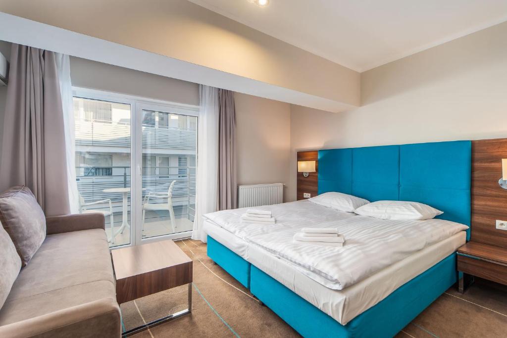 ミエンジズドロイェにあるW Rent like home - Hotel Room 210のベッドルーム(青いベッド1台、ソファ付)