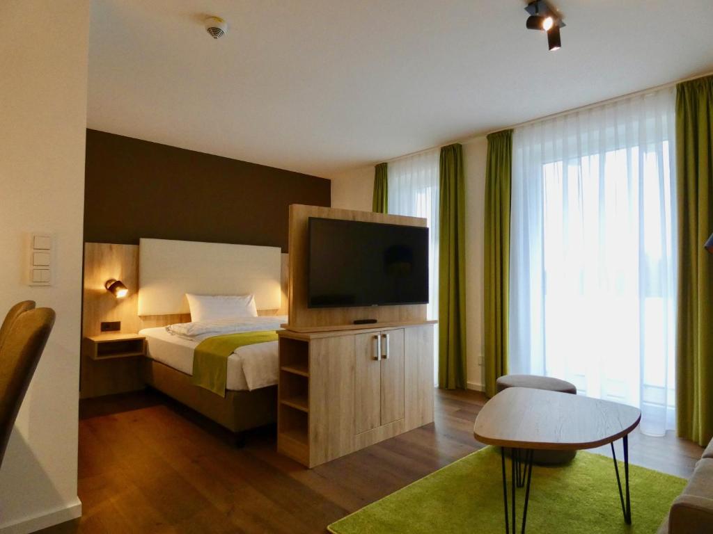 a bedroom with a bed and a flat screen tv at Living Hallertau in Rudelzhausen