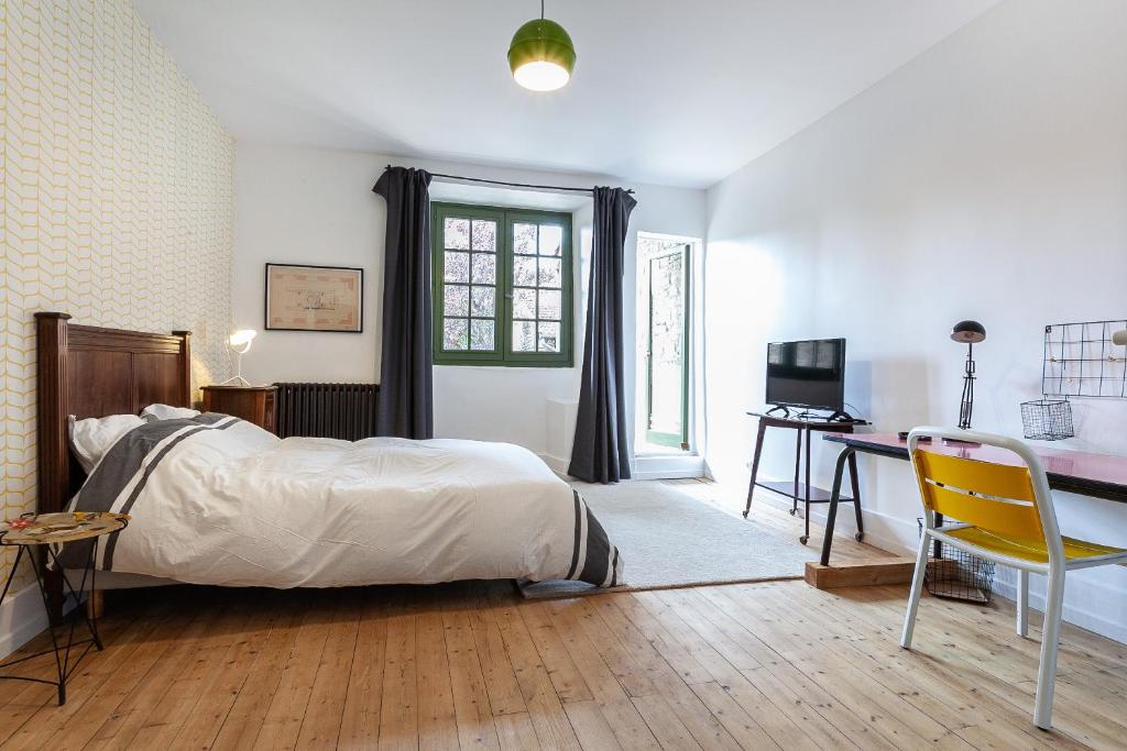 1 dormitorio con 1 cama y escritorio con ordenador en La maison des couturières, en Cluny