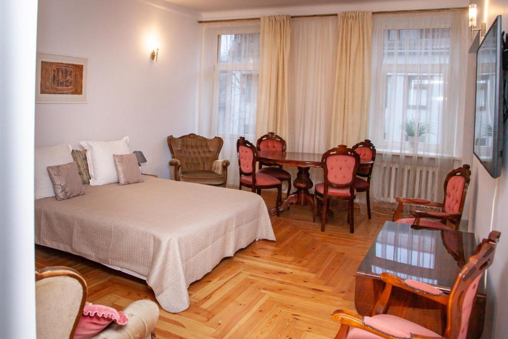 um quarto com uma cama, uma mesa e cadeiras em KaunasInn - AM em Kaunas