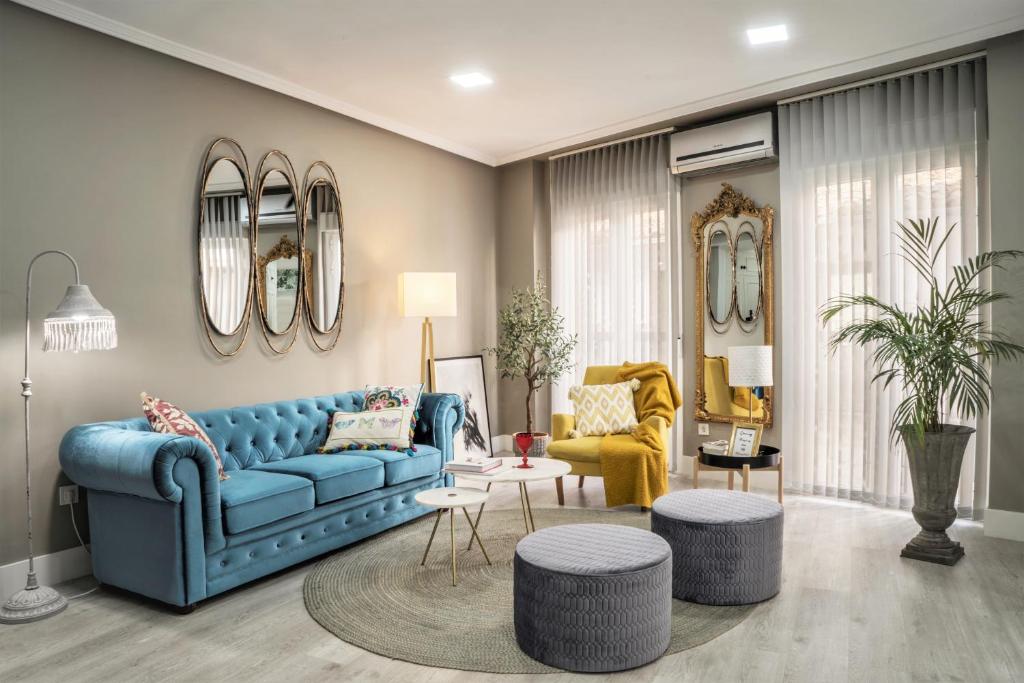 un soggiorno con divano blu e 2 sedie di Deluxe Rue Bohème a Plasencia