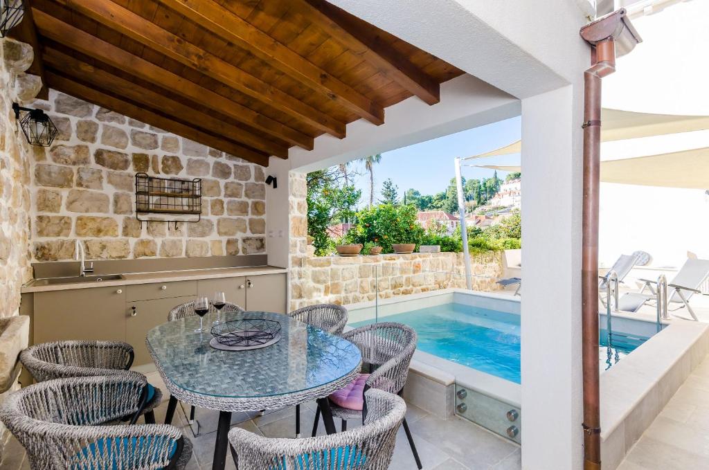a patio with a table and chairs next to a swimming pool at Apartments Villa Agava in Cavtat