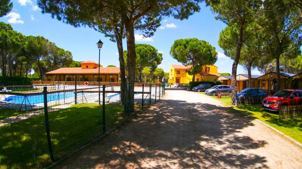 a fence in front of a property with cars parked at Camping Riberduero in Peñafiel