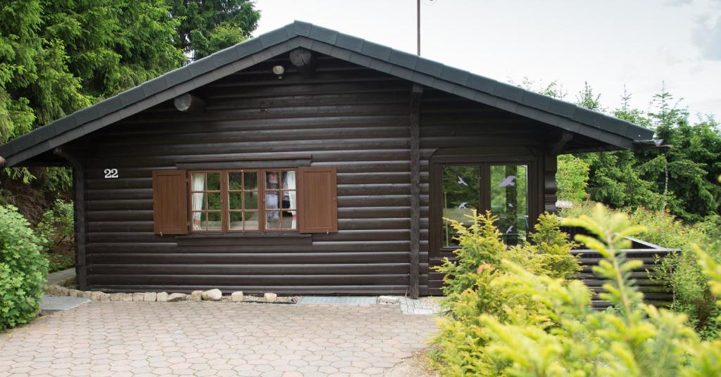 a small black cabin with a window in a garden at Schwedenhaus Uplandalm Willingen in Bömighausen