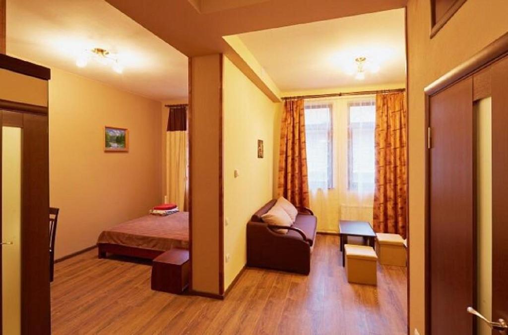une chambre d'hôtel avec un lit, un canapé et une fenêtre dans l'établissement Apartment on Lychakivska 6-A, à Lviv